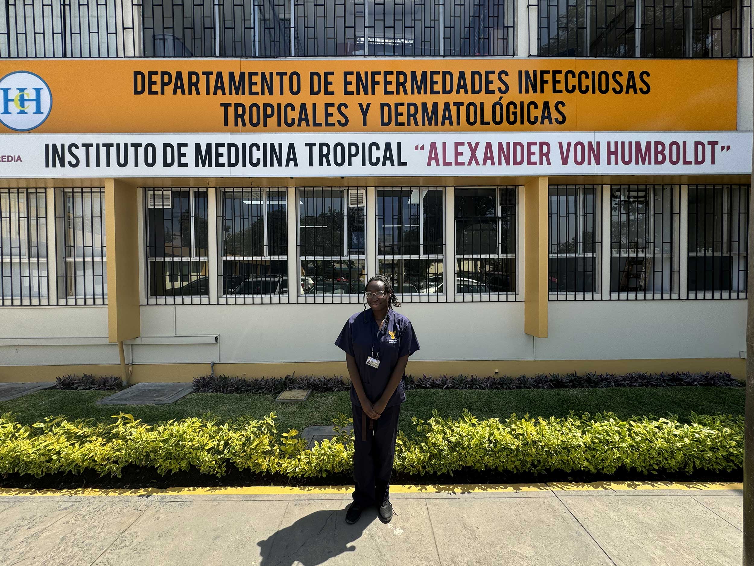 Photo of Ayolola in front of the Tropical and Dematological Infectious Diseases at Alexander von Humboldt Tropical Medicine Institute, Universidad Peruana Cayetano Heredia (UPCH) in Lima, Peru.